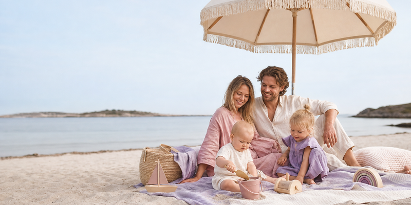 Familie pakker sammen etter en fin stranddag i den lave kveldssola